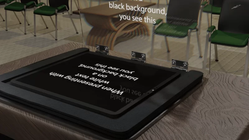 The image depicts a teleprompter with a securely placed iPad. The text on the iPad is reflected onto a glass panel in front of the presenter, enabling them to maintain eye contact while reading the script.