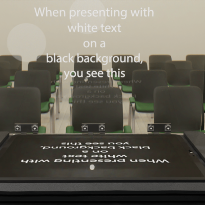 The image showcases a presenter confidently reading easily readable text from a sleek teleprompter in front of an engaged audience.